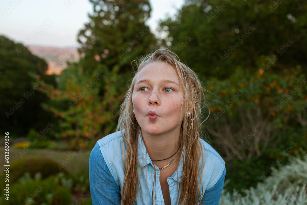 Teen girl makes fish gesture in nature Teen girl makes fish gesture in nature