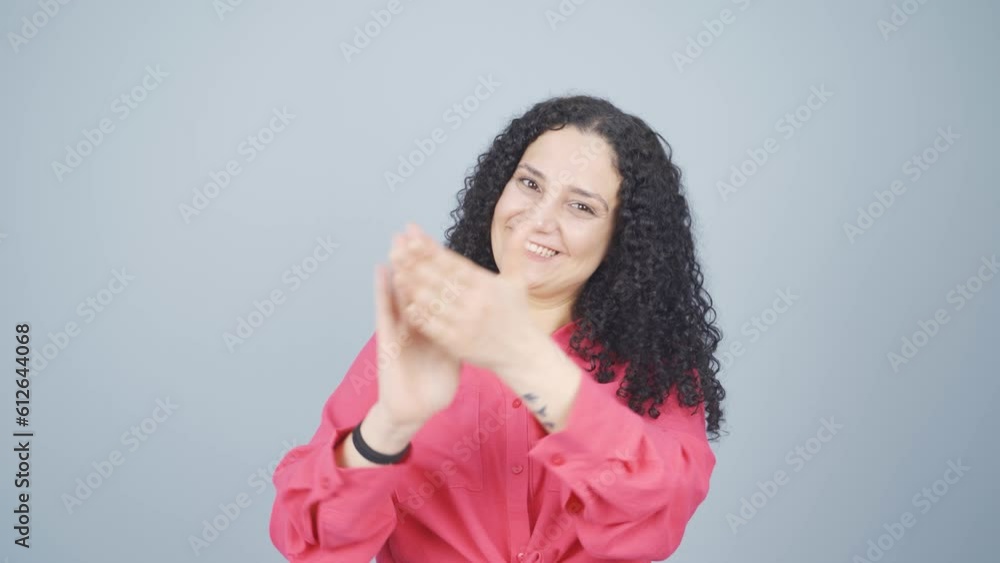 Young woman clapping excitedly to camera. Young woman clapping excitedly to camera.