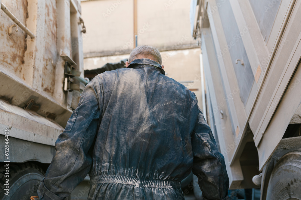 Unrecognizable worker standing between trucks Unrecognizable worker standing between trucks
