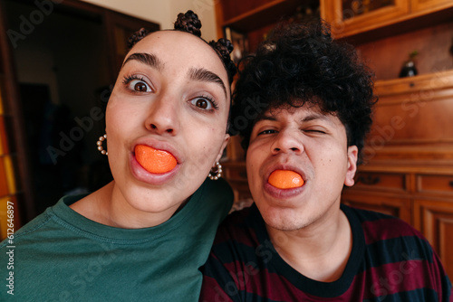Funny self-portrait of couple eating a clementine photo