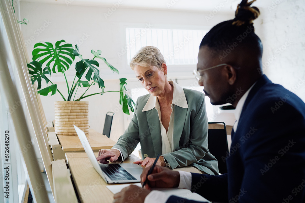 Colleagues working together in an office space Colleagues working together in an office space