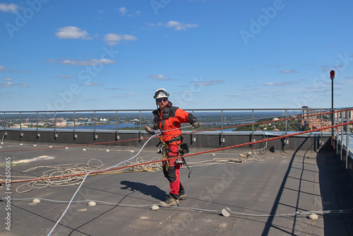 A specialist is repairing the roof. Rope access