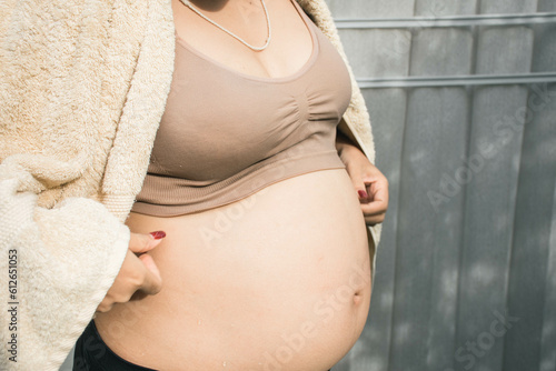 6 months pregnant woman showing big belly.