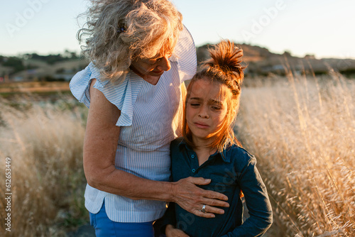 Grandmother comforting grandson outdoors