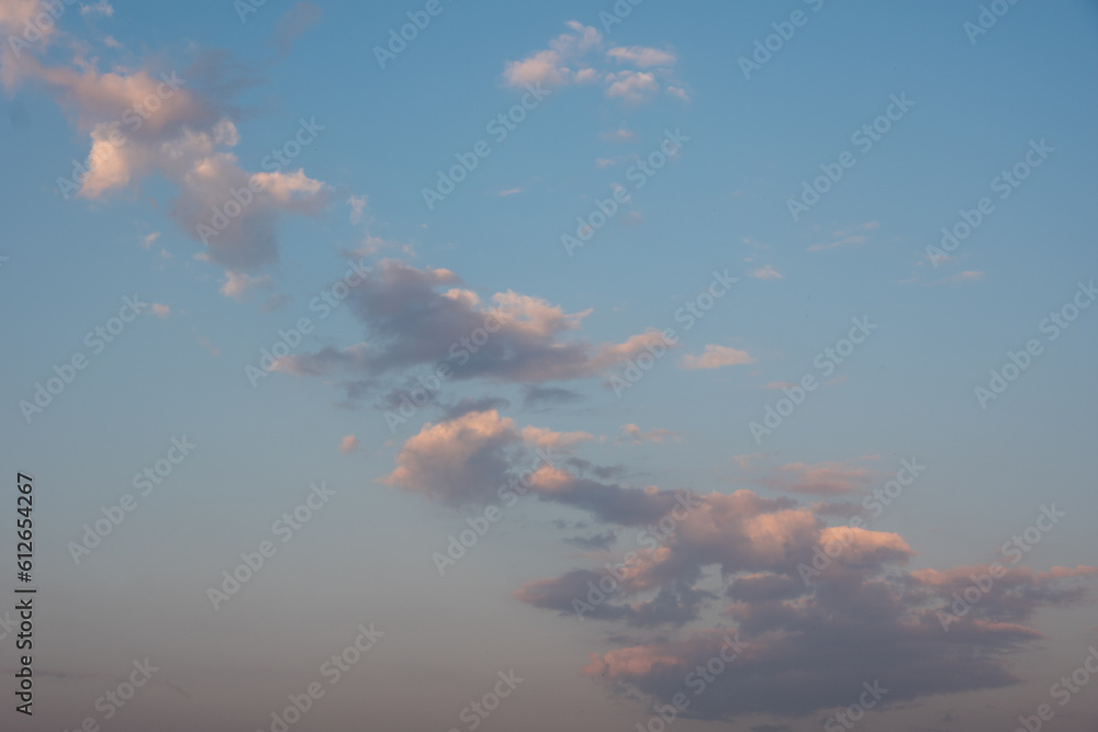 sunset sky with pink clouds, diagonally stripe, grey above. Whispy pink clouds and blue sky diving frame diagonally. Cirrus and cirrocumulus clouds form a colored triangle. sunset sky with pink clouds, diagonally stripe, grey above. Whispy pink clouds and blue sky diving frame diagonally. Cirrus and cirrocumulus clouds form a colored triangle.