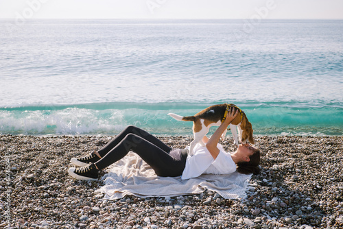 A young woman kisses her dog in to nose photo