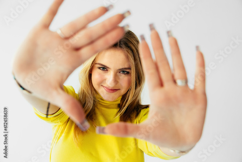 Cute Teenage Girl with Hands Up Making a Frame Crop photo