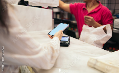 Woman paying with smartphone in an establishment