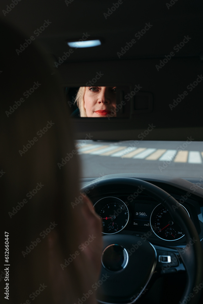 Middle-aged woman does makeup while sitting in car. Middle-aged woman does makeup while sitting in car.
