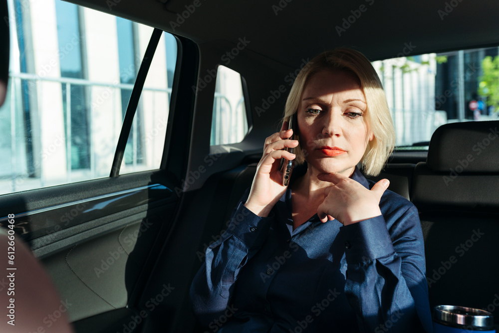 Businesswoman in car with phone. Businesswoman in car with phone.