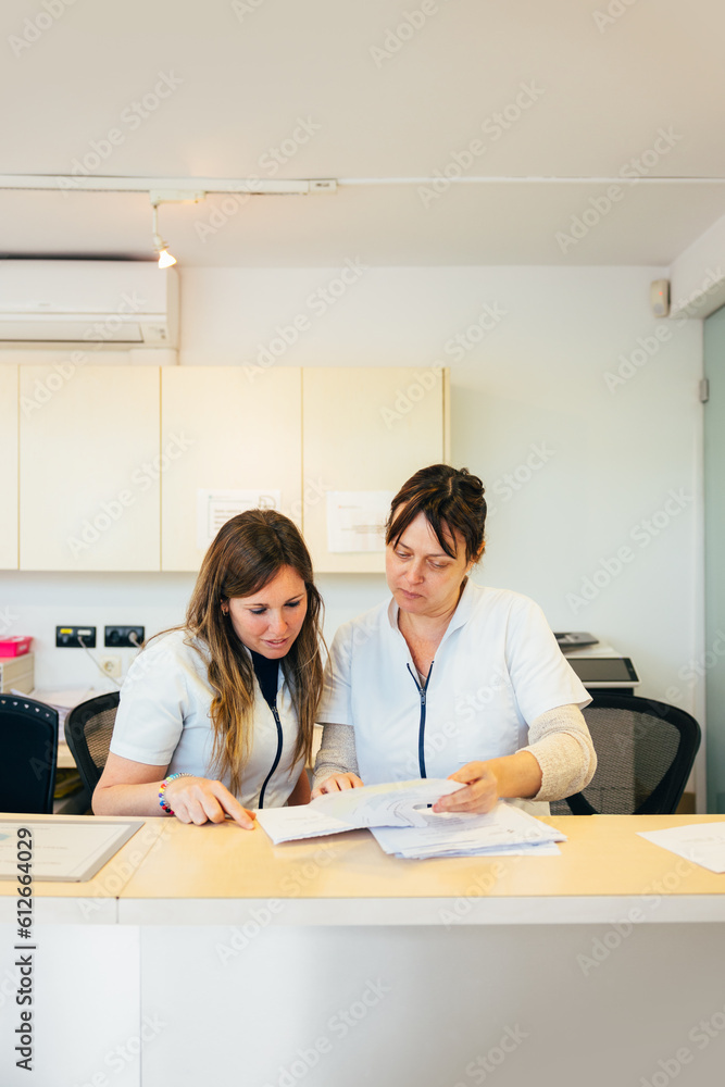 Cheerful women in medical uniform working with papers