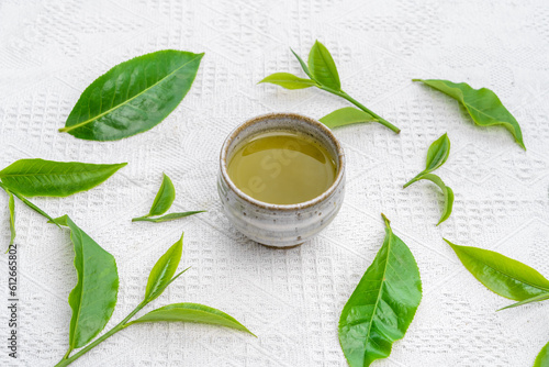 hot green tea in a cup on a white cloth background   