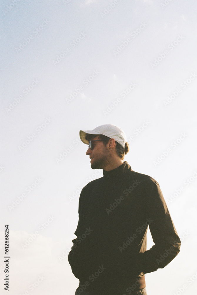 A tall man wearing a white cap and a black jacket. A tall man wearing a white cap and a black jacket.