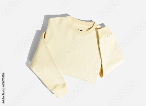 A folded yellow sweat shirt on a light grey background. photo