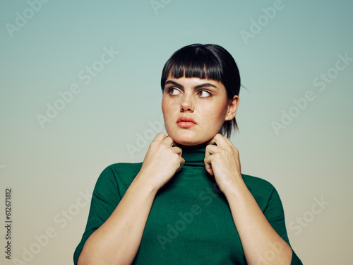 Woman with mistrust expression looking to the side touching her neck photo