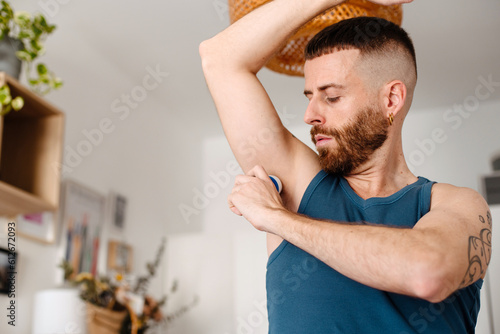 Man applying deodorant on his armpit