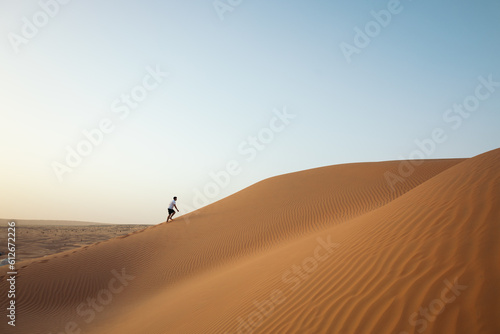 Man walking through the dunes of the Sahara desert photo