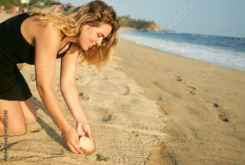woman releasing turtles into the ocean photo