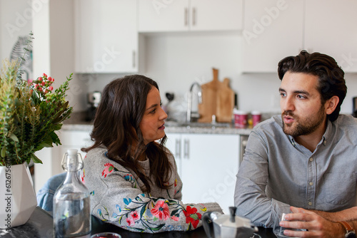 Coworkers drink coffee together in office kitchen photo