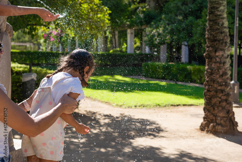 Girl cools off with water at park