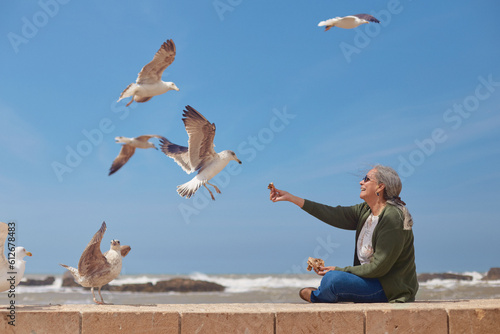 At Essaouira beach, an elderly tourist kindly feeds the local wildlife