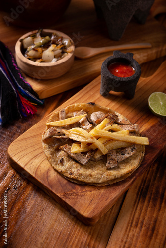 Beef steak taco with french fries. Very popular taco in Mexico called Taco de Bistec, homemade roast beef served on a corn tortilla. Mexican street food.