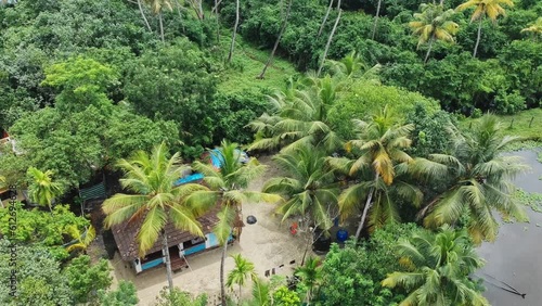 Aerial view of a rural house in India , Little house by the lake , Aerial view of small houses standing in coconut groves , photo