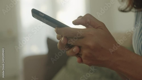 Side view. Hand of Asian woman using texting mobile phone or chat. Close- up business women hand
