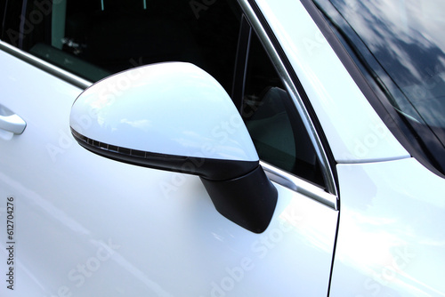 White Left side rear-view mirror on a modern car. View from inside the car. Rear view mirror with reflection. 