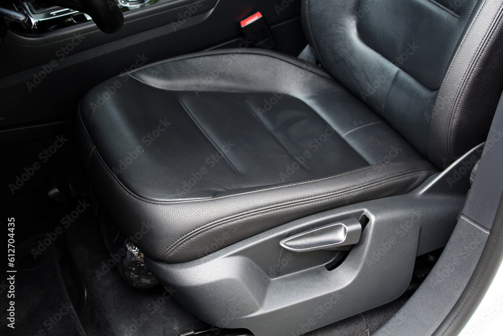 Obraz premium Modern luxury car black leather with alcantara interior. Part of black leather car seat. Interior of prestige car. Leather seats isolated. Adjustable car seat position.