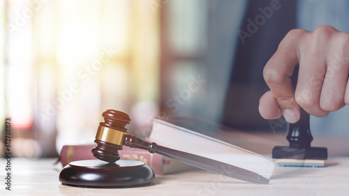 Wooden judge gavel on table ,justice in punishment of offenses and criminal verdicts ,concept of law and justice ,Lawyer or judge examining documents ,legal service lawyer ,court proceedings