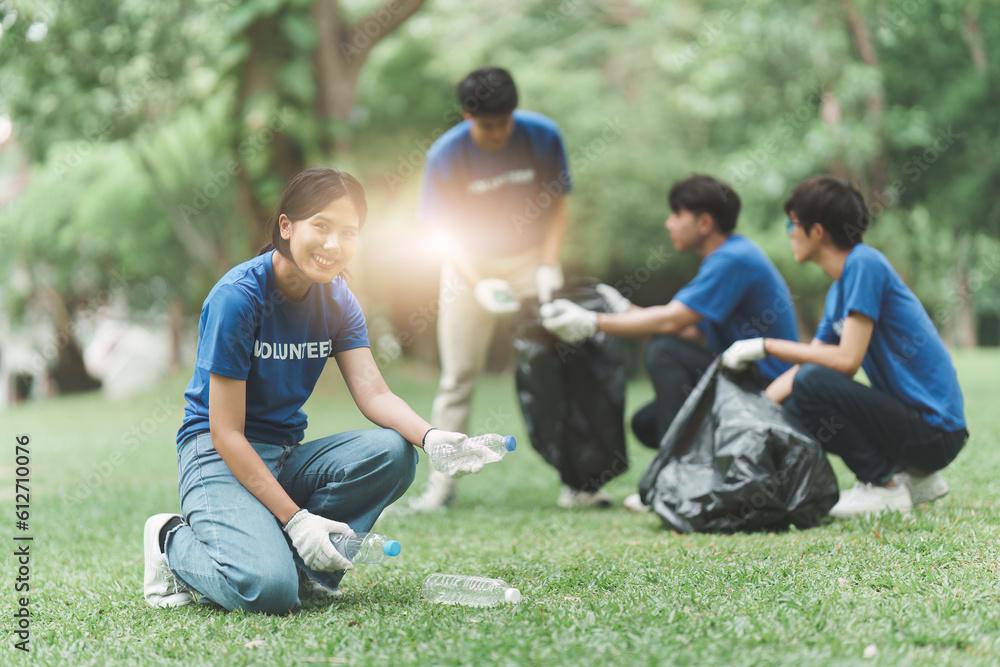 Young Asian Volunteers with garbage bags cleaning park area. Ecology, Charitable organization concept Young Asian Volunteers with garbage bags cleaning park area. Ecology, Charitable organization concept