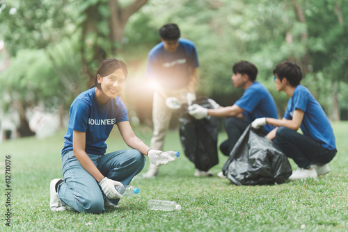 Young Asian Volunteers with garbage bags cleaning park area. Ecology, Charitable organization concept