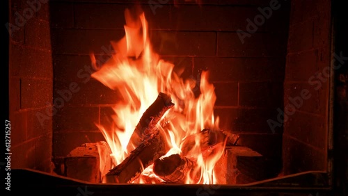 Home fireplace with red flame and firewood. 4K video relaxing endless footage