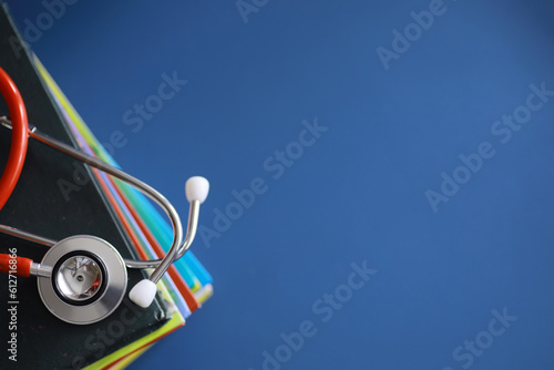 stethoscope on stack of medical guide book for doctor learning treatment at hospital.