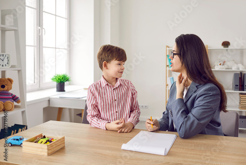 Child learning correct pronunciation with speech therapist. Woman language pathologist helps little boy articulate sounds or get rid of his stammering, stuttering impediment. Speech therapy concept photo