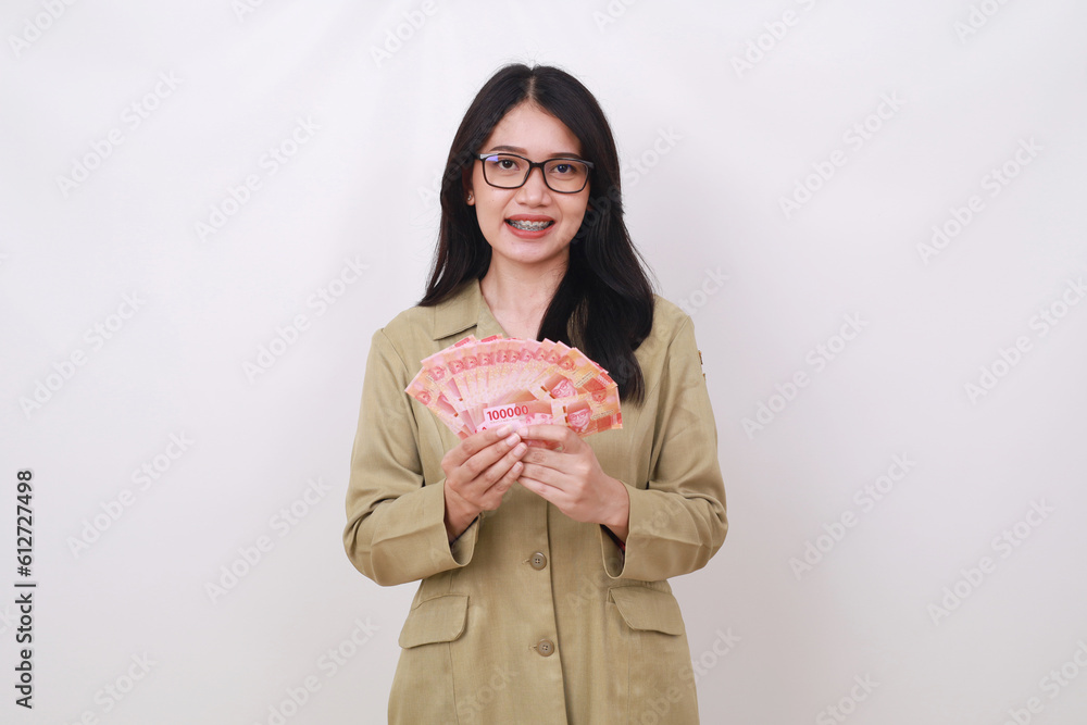 Happy asian teacher holding Indonesian banknotes while looking at the camera. Isolated on white Happy asian teacher holding Indonesian banknotes while looking at the camera. Isolated on white