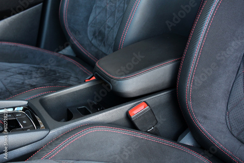 Leather sport car interior. Armrest with Seat Adjustment Buttons. Sport Car armrest with storage box. Sport Car interior with carbon fiber trims, leather seats and black stitches. 