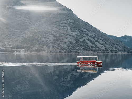 Red boat in the sea floats on azure water 