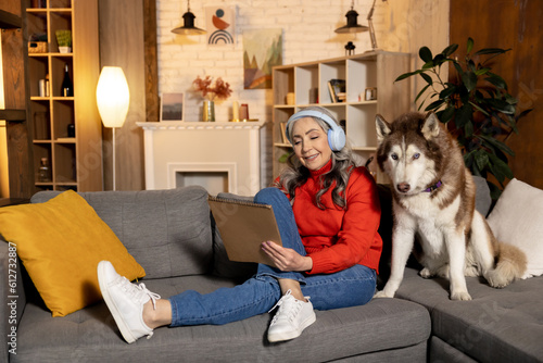 Good-looking senior woman with a dog at home © zinkevych