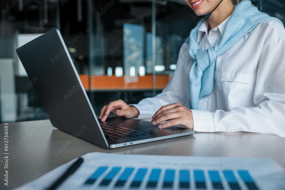 Young woman working at the office and typing on a laptop Young woman working at the office and typing on a laptop