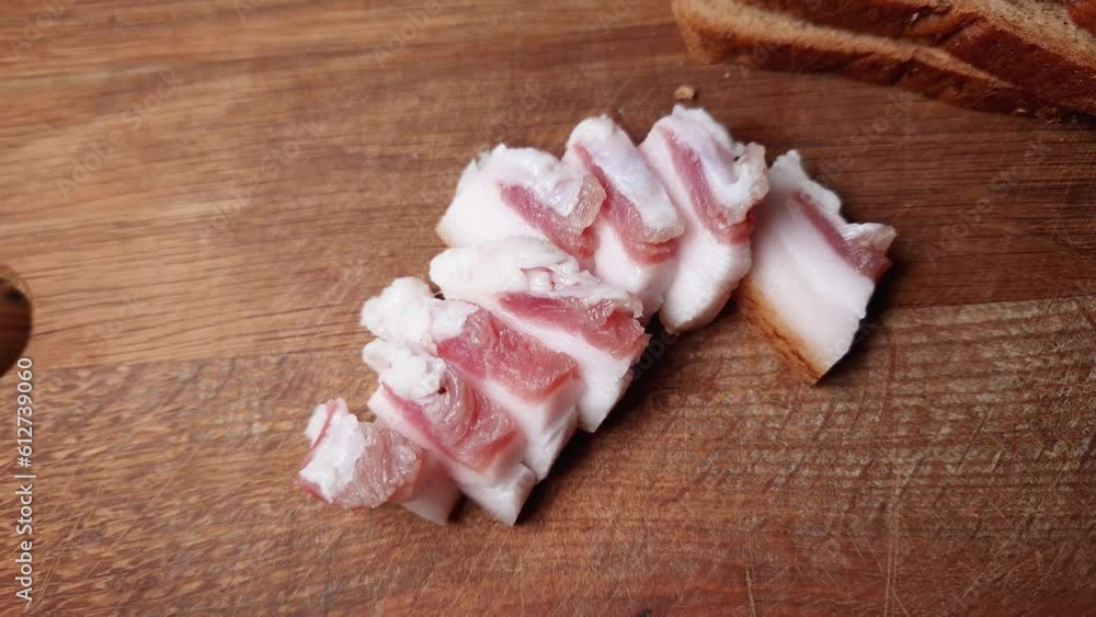 Slices of salted pork fatback on cutting board, close-up Slices of salted pork fatback on cutting board, close-up