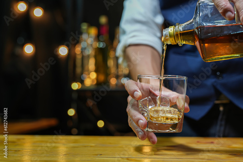 Bartender pouring Whiskey, on bar,