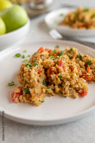 Fried rice with scrambled eggs and vegetables on a plate. Cooked with brown rice