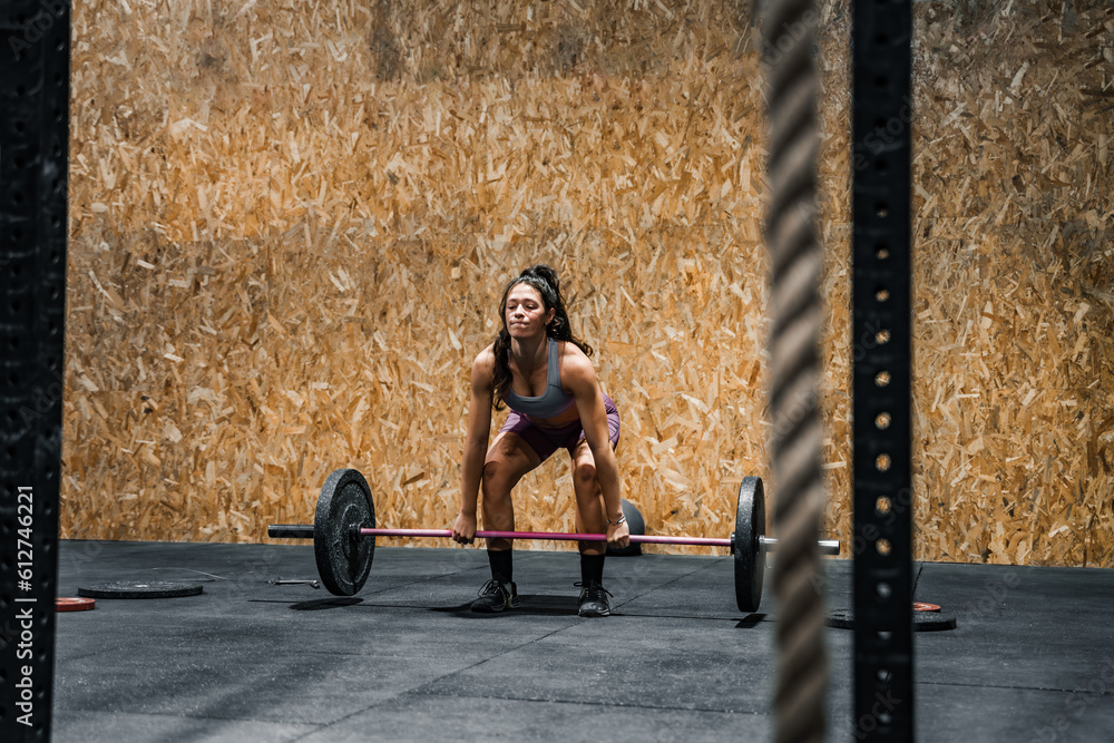 woman carrying a heavy barbell in the gymnasium