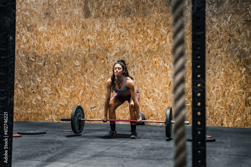 woman carrying a heavy barbell in the gymnasium