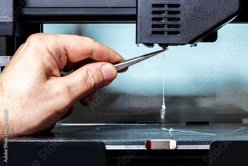 maintenance of a 3d printer, cleaning the nozzle, inserting the filament photo