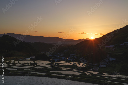 A farming village at dusk, beautiful scenery of rice paddies just before the sun sets © 隼人 岩崎