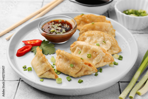 Delicious gyoza (asian dumplings) with green onions and soy sauce on table, closeup