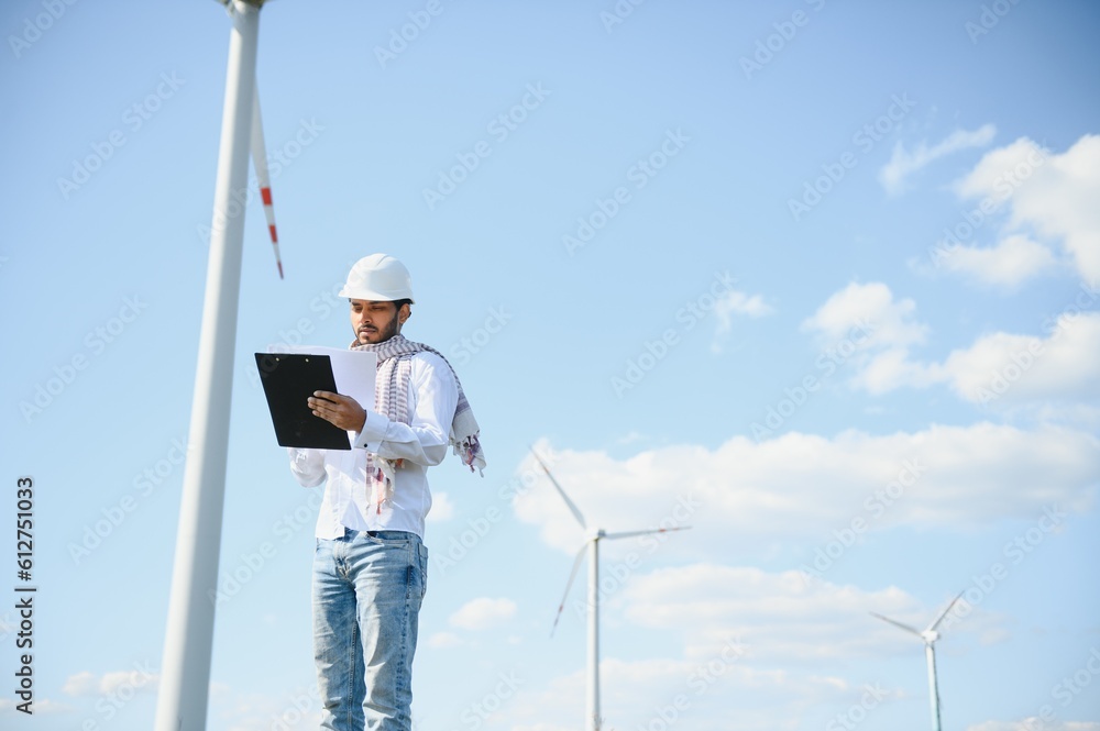 Indian Engineer in wheat field checking on turbine production Indian Engineer in wheat field checking on turbine production